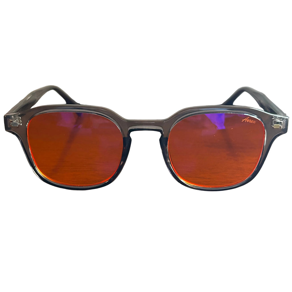 Sunglasses with red lenses and black frames on a wooden surface