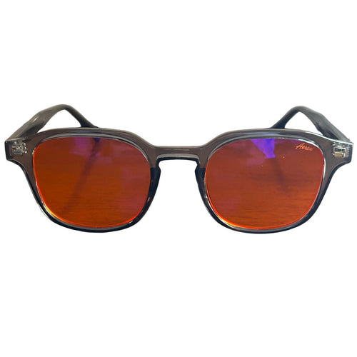 Sunglasses with red lenses and black frames on a wooden surface
